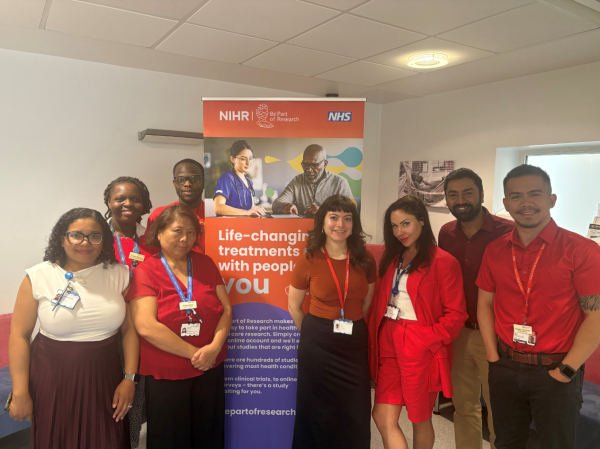 Staff from the NIHR King's Clinical Research Facility standing in front of a 'NIHR Be Part of Research' banner