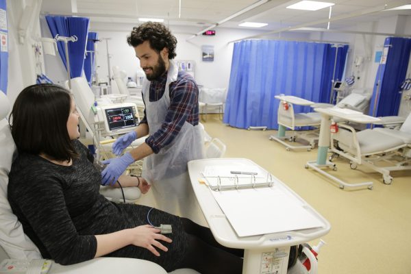 Nurse with patient in the trials procedure room at the Experimental Medicine Facility