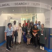 Dr Austin Kulasekararaj and members of the Clinical Research Facility (CRF) team standing outside of the main entrance of the CRF team)